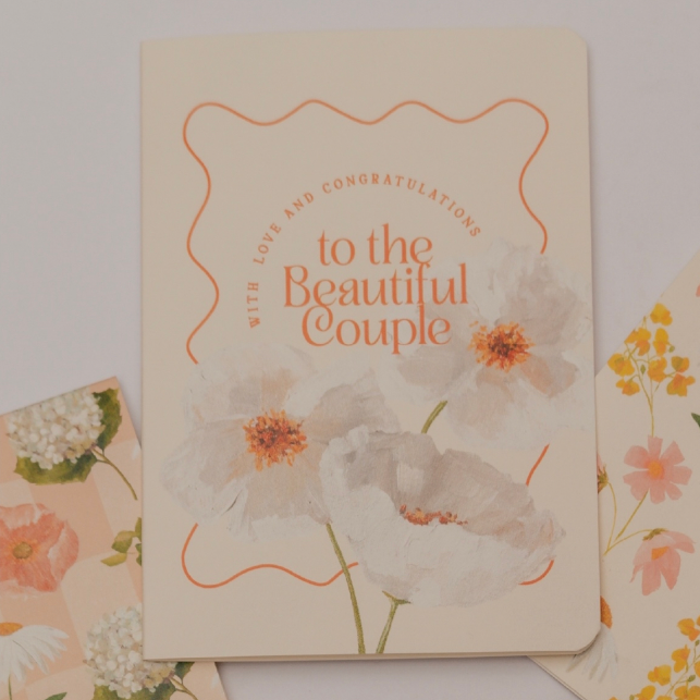Greeting card with floral design and text 'Congratulations to the Beautiful Couple' on a light background.