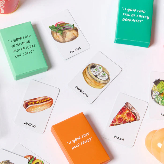 Card game with food-themed cards and question prompts on a white surface